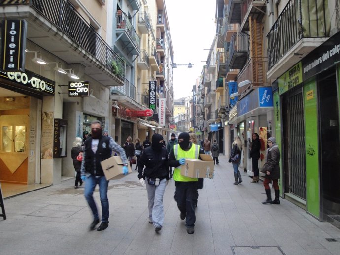 Agentes se llevan material de un registro en un piso de Lleida
