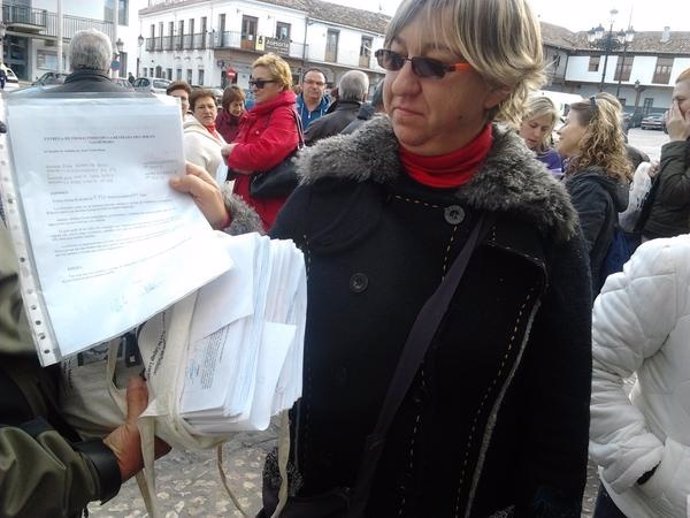 Una de las vecinas sujeta el documento contra los parquímetros de Valdemoro