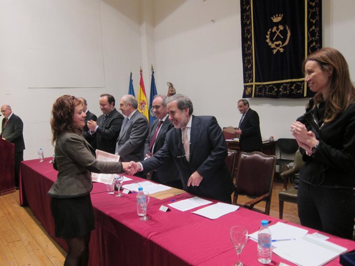 Loreto Ordóñez (derecha) aplaude a una estudiante que recoge el título.