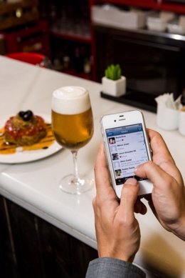 Teléfono móvil smartphone iPhone en un bar cafetería cerveza tapa