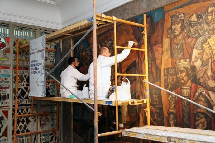 Dos operarios limpian el mural de Vela Zanetti