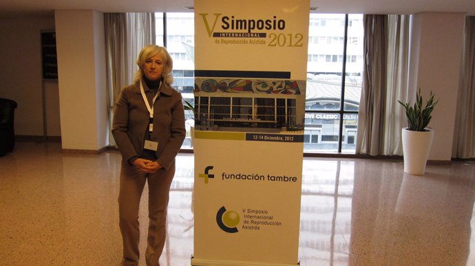 La doctora de la Clínica Tambre, Rocío Núñez, posa junto al cartel del simposio