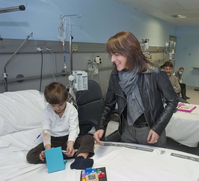 La consejera, con un niño atendido en el Hospital de Día de oncología pediátrica