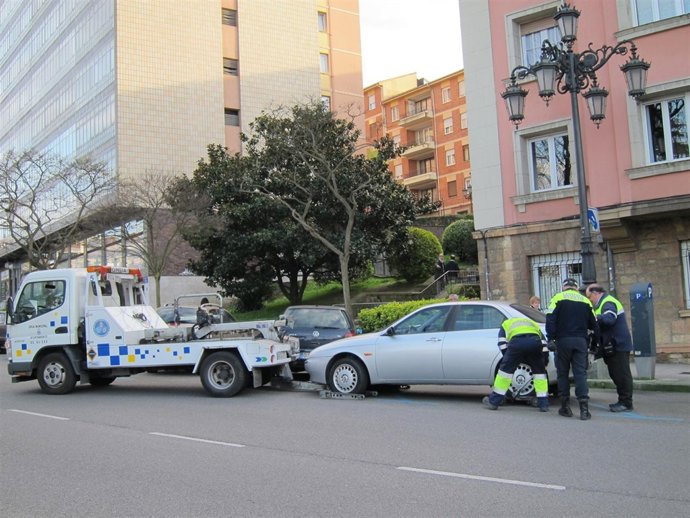 La grúa municipal retira un coche en Oviedo.