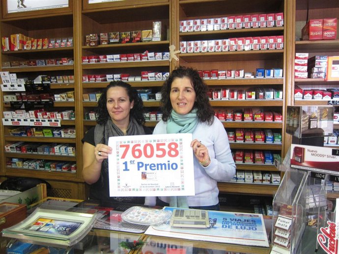 Las propietarias del estanco muestran el número premiado 