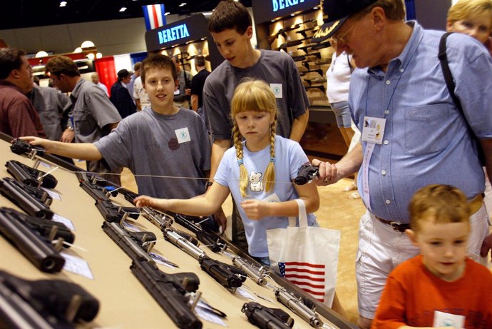 Gente comprando armas en una feria de la Asociación Nacional del Rifle en EEUU