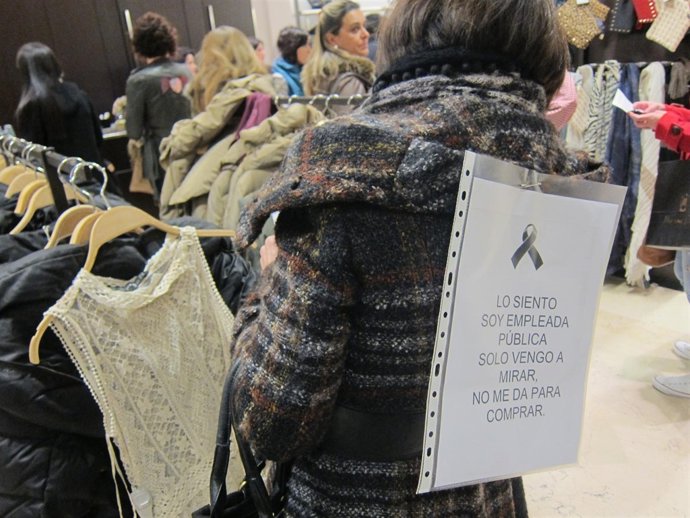 Trabajadora pública visita una tienda con el cartel de la protesta.