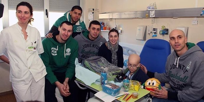 Los jugadores del Joventut haciendo entrega de regalos a niños enfermos