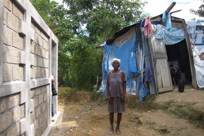 Anciana Al Lado De Su Choza Y De Su Nueva Casa En Haití