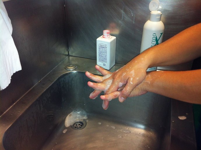 Una médico se lava las manos con solución hidroalcohólica