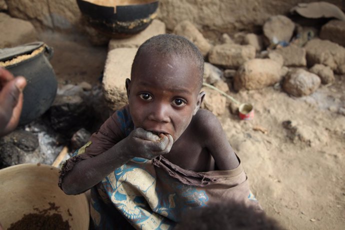 Un Niño Maliense Comiendo Restos De Comida Para El Ganado