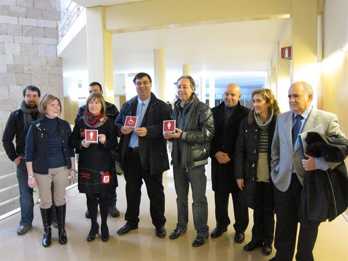 Corres y representantes de CERMI y de los hosteleros muestran los pictogramas