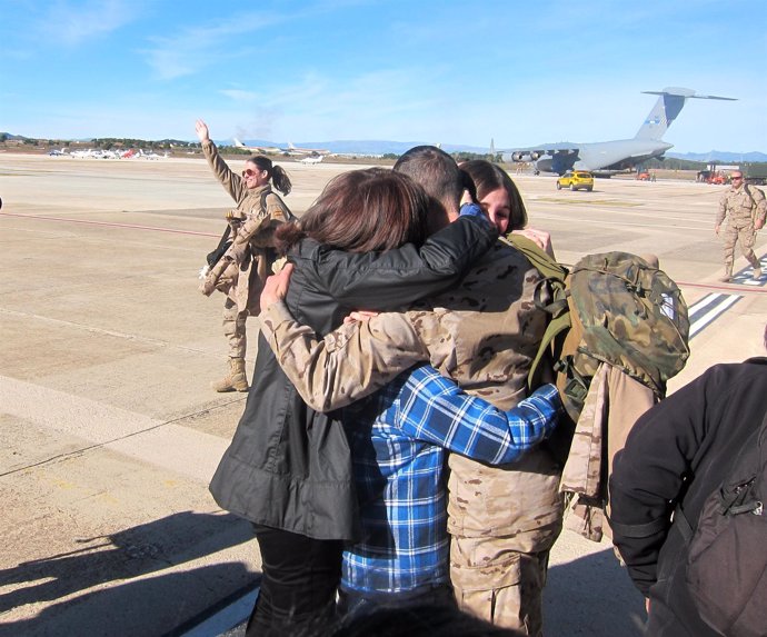 Uno de los militares se abraza a su familia tras bajar del avión