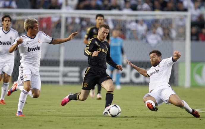 Beckham disputa un balón con Coentrao y Xabi Alonso