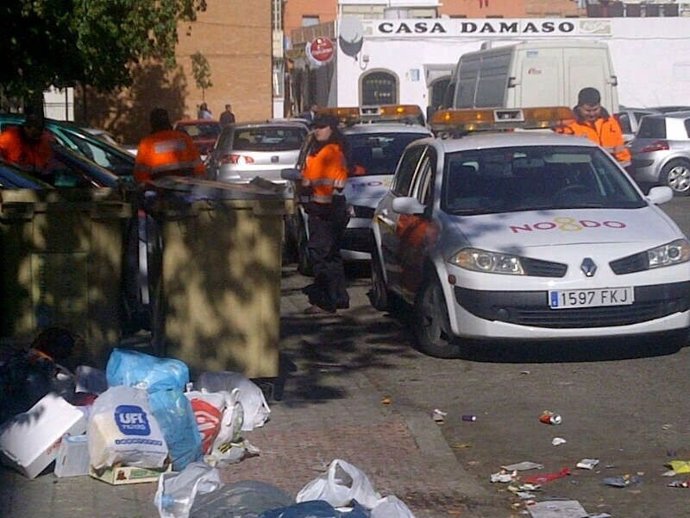 Miembros de Protección Civil junto a los contenedores de basura.