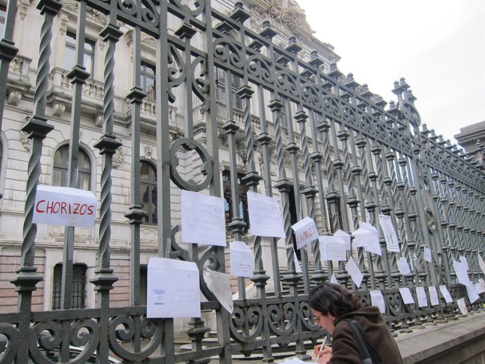 Una viandante deja su protesta ante el Parlamento asturiano