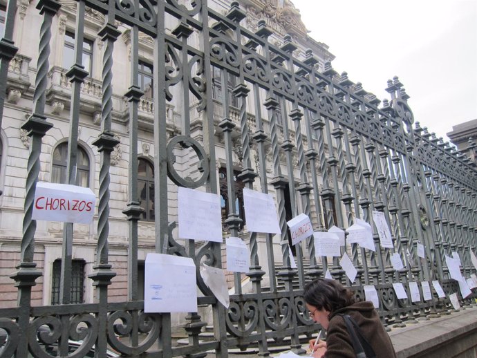 Una viandante deja su protesta ante el Parlamento asturiano
