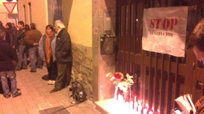 Velas y flores ante la casa del vecino que se ha matado antes de su desahucio