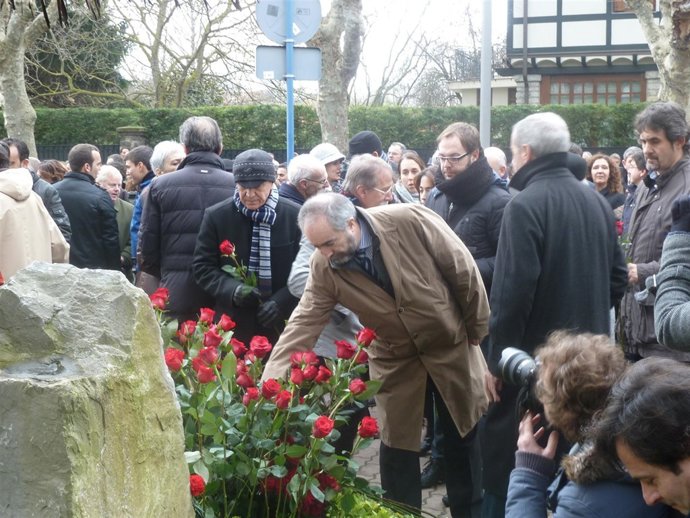 Rafa Larreina coloca una rosa en el monolito de homenaje a Buesa.