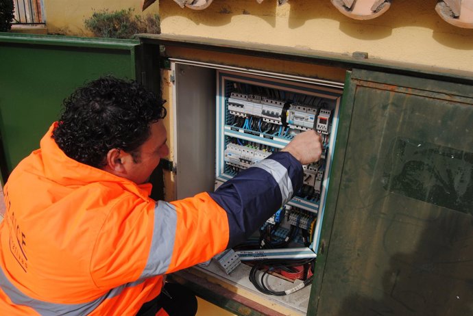 Un operario con unos cuadros de luz 