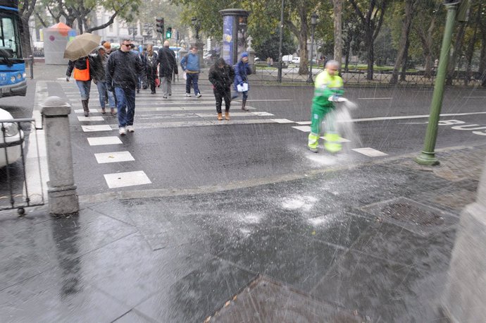 Operarios esparciendo sal por la calle de Madrid