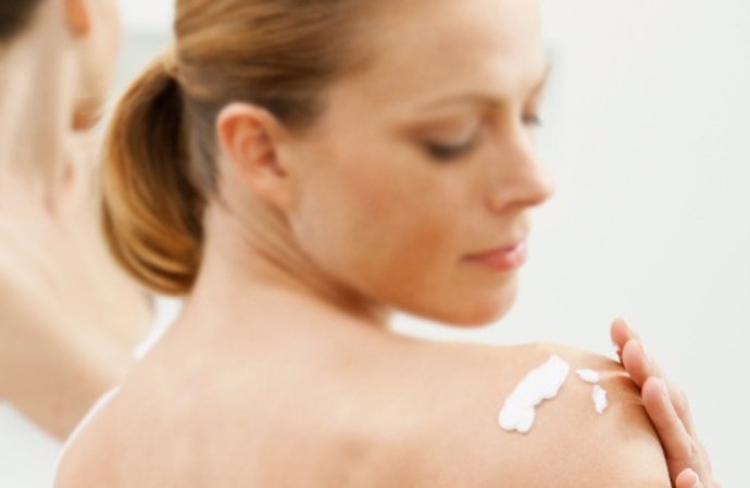Imagen de una mujer aplicándose la crema 'Pliazon' de Merck Serono