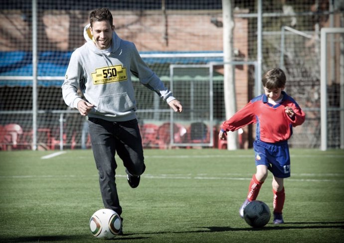 El jugador del FC Barcelona Jordi Alba con un niño del Hospitalense