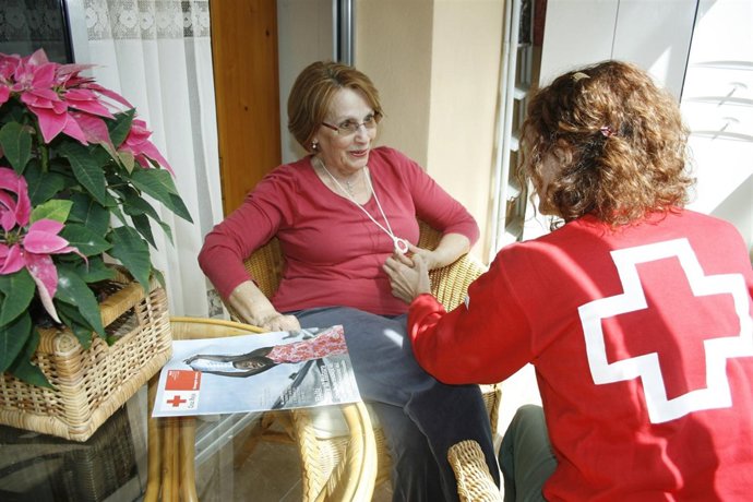 Una voluntaria de Cruz Roja atiende a una mujer
