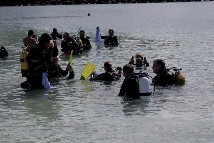 Buceadores limpiando en la playa Anfi