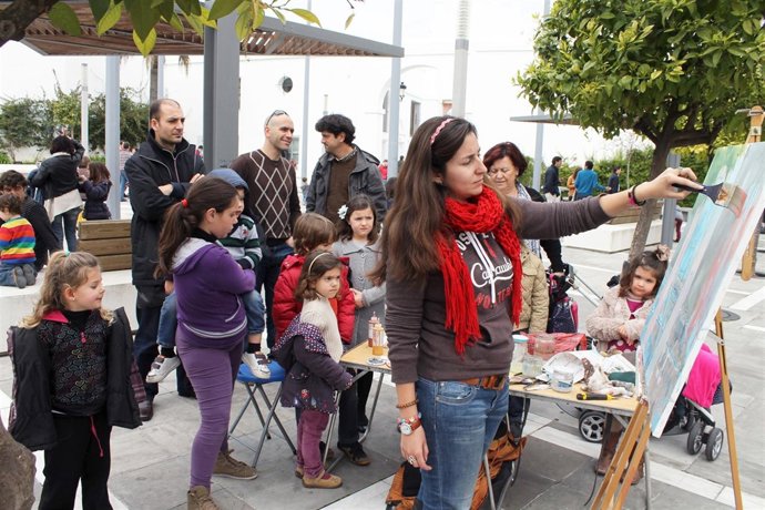 Pintora inmortalizando la arcada de la Plaza de la Constitución de Tomares