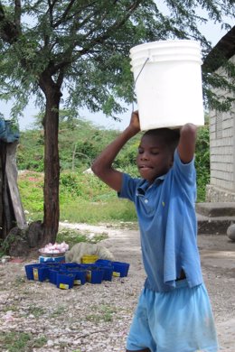 Niño Lleva Un Cubo De Agua Sobre Su Cabeza, Haití