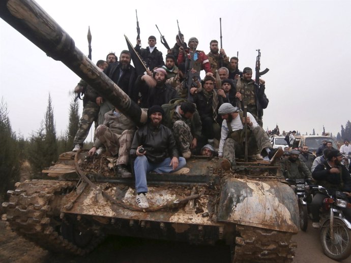 Rebeldes sirios desfilan por una carretera tras combatir contra el ejército