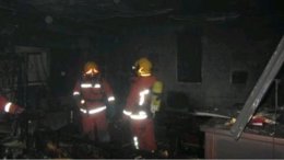 Bomberos en el interior de la vivienda afectada por el fuego en Torrent