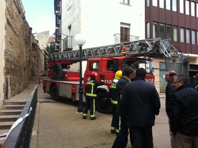 Los bomberos y el alcalde en el lugar donde se ha desplomado la muralla.