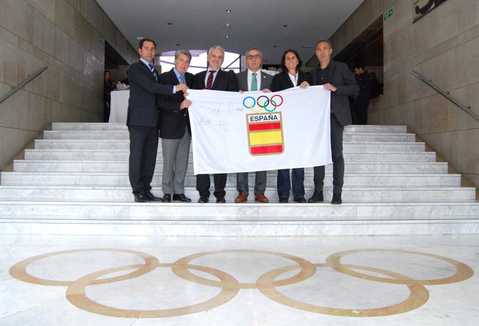 Representantes COE y tenis con la bandera del COE firmada