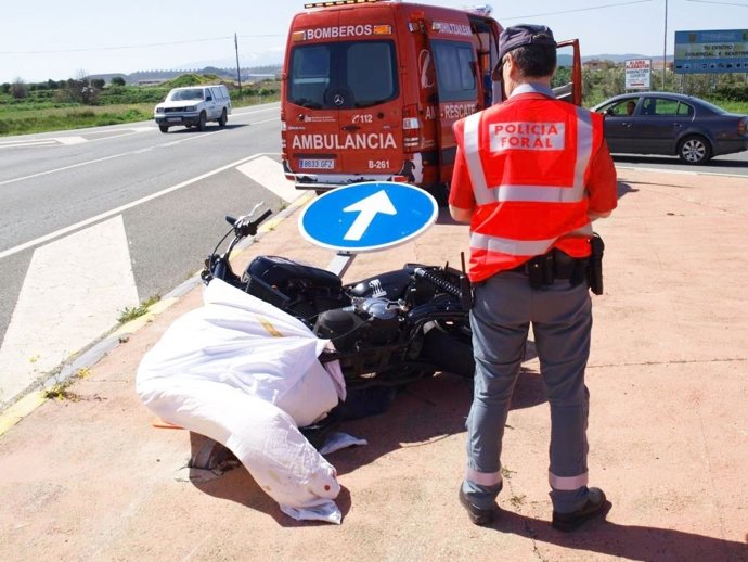 Un agente de la Policía Foral junto a la motocicleta que conducía la víctima