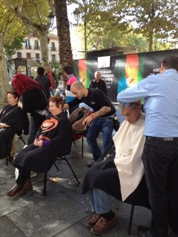 Imagen de los peluqueros en un corte solidario en Plaza Nueva