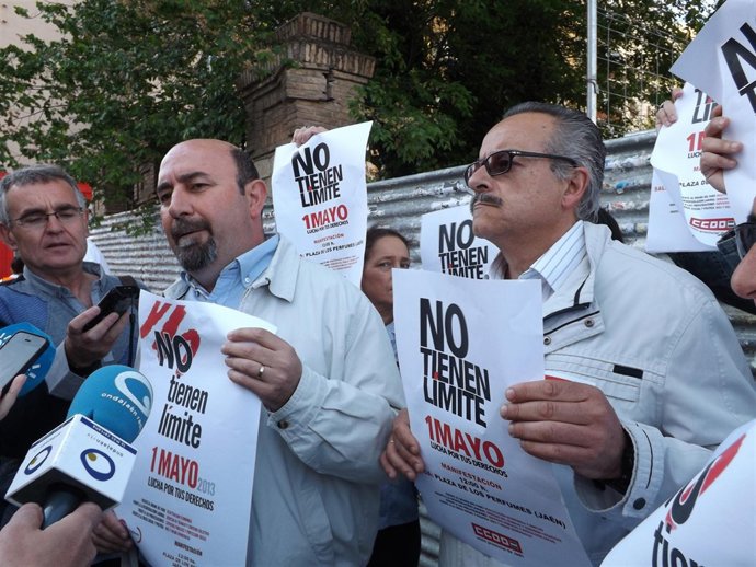 Salazar y Moral sostienen carteles del próximo Primero de Mayo.