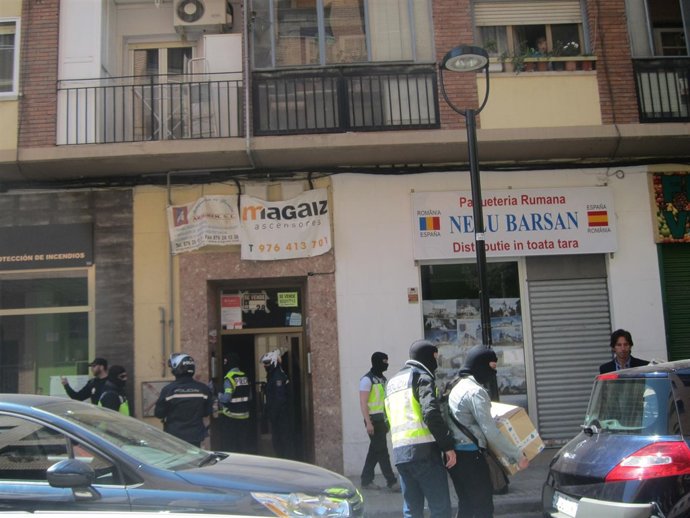 Un policía portando la caja con el material intervenido en el registro.