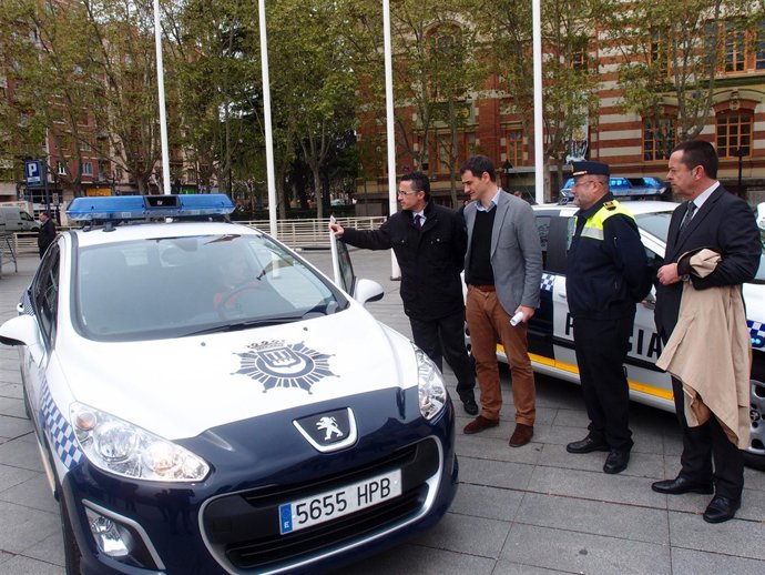 Sáinz, con otros asistentes a la presentación, observa uno de los coches     