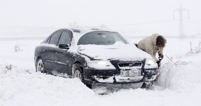 Un hombre desentierra su coche de la nieve