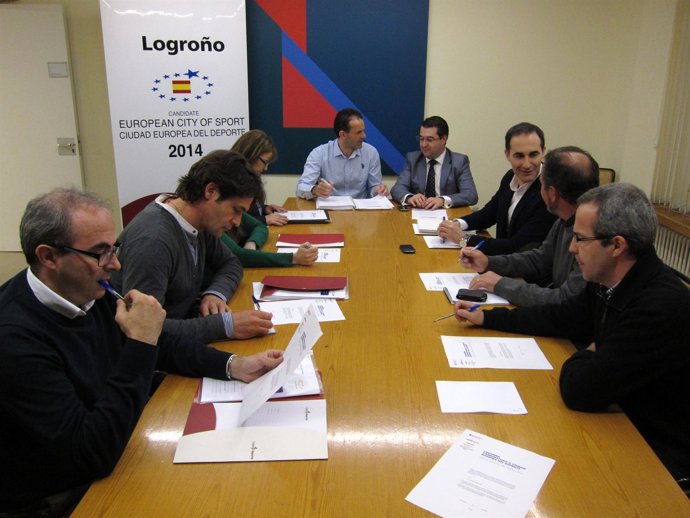 Reunión de la comisión preparatoria con el logo al fondo