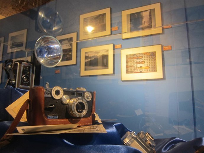 Cámara antigua junto a fotografías en el Museo del Comercio