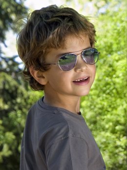Imagen de un niño protegiéndose del sol con una gafa con protección ultravioleta