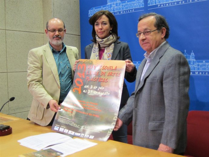 Ceballos (centro) muestra el cartel de la Escuela 