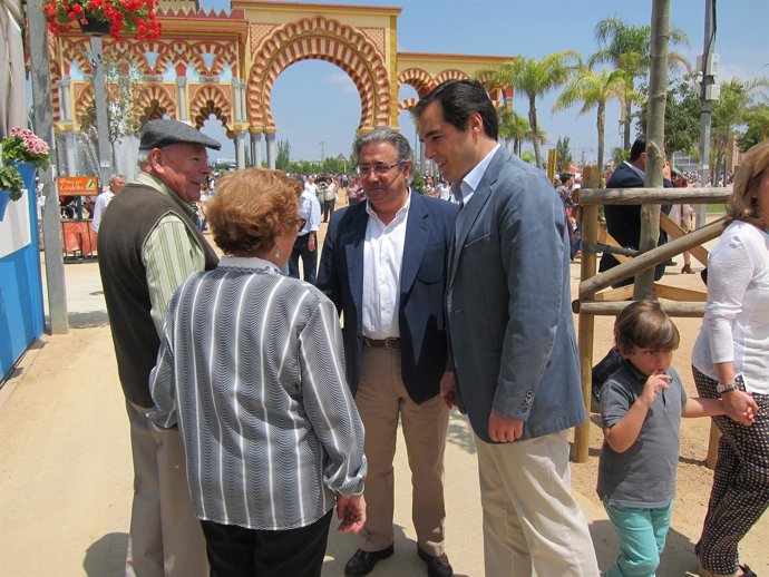 Zoido y Nieto saludan a un matrimonio en la Feria de Córdoba