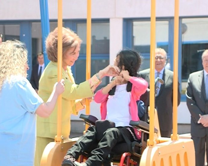 La Reina columpia a una niña con parálisis cerebral