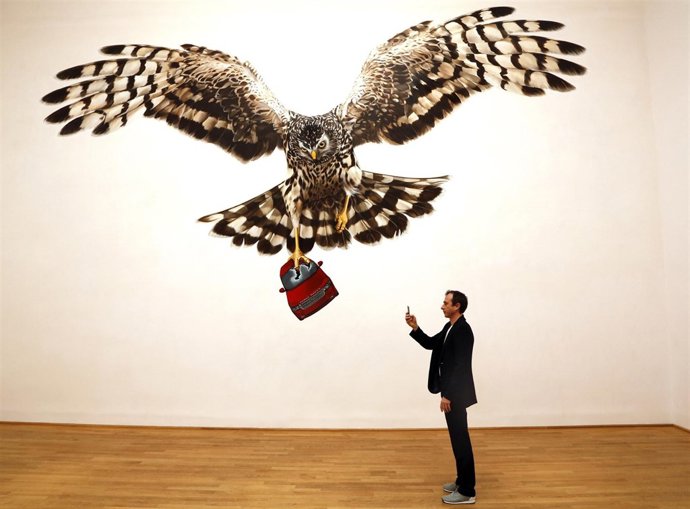 Visitor takes picture in front of installation called " The Sandringham Estate, 