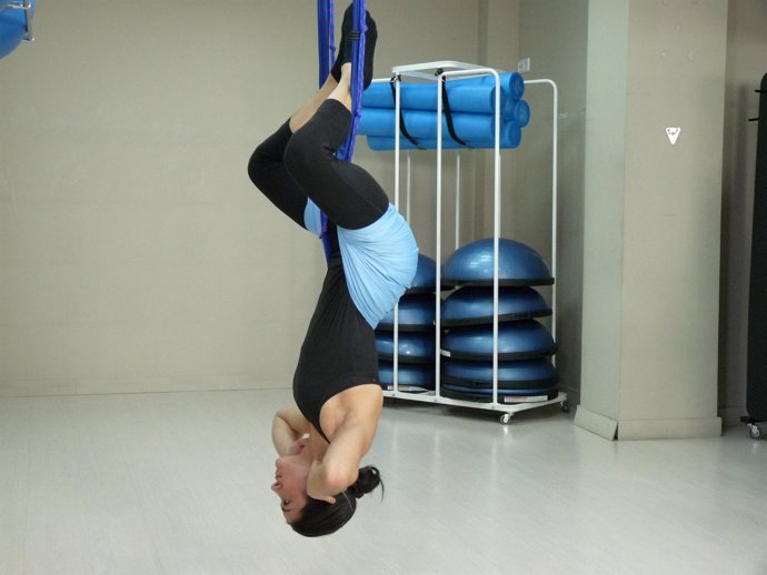 Imagen de una mujer realizando un ejercicio en suspensión