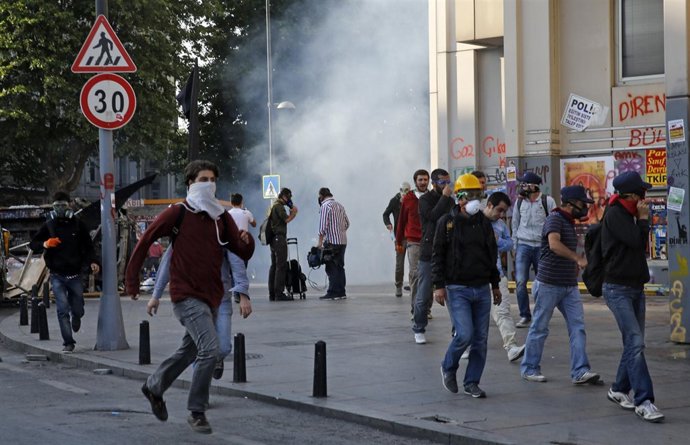 Manifestantes escapen de gases llarimosos nel desagospiu de la plaza Taksim